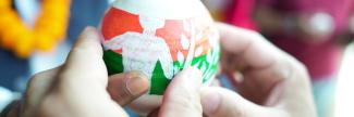 Two hands holding a piggy bank with the JP RWEE logo.