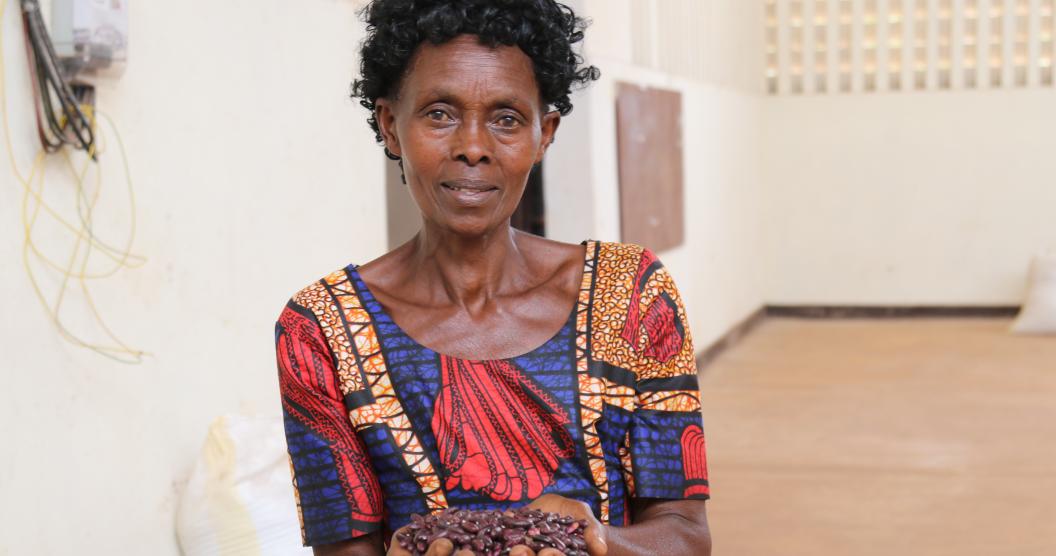 Woman holding beans looks into the camera